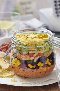 Katmanlı Meksika sandviç kavanoz Mısır, fasulye, marul, peynir, kırmızı biber, marul ve tortilla cips ile