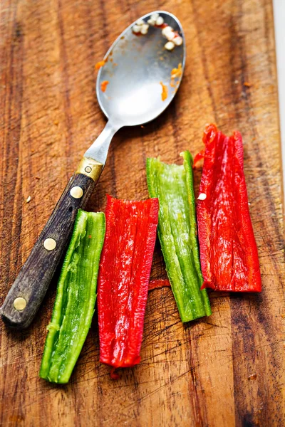 Deseeding green and red chilli peppers before chopping — Stock Photo, Image