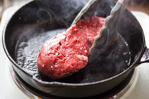 Bife cru angus frito em óleo vegetal, ferro fundido — Fotografia de Stock