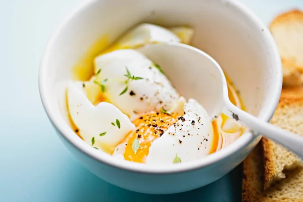 Mjuka kokt ägg med salt, peppar och timjan i vit skål på blå bakgrund — Stockfoto