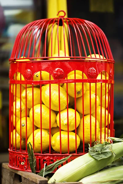 Lemons in red cage on food display — Stock Photo, Image