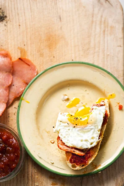 Bread slices with tomato relish, turkey rasher and fried egg — Stock Photo, Image