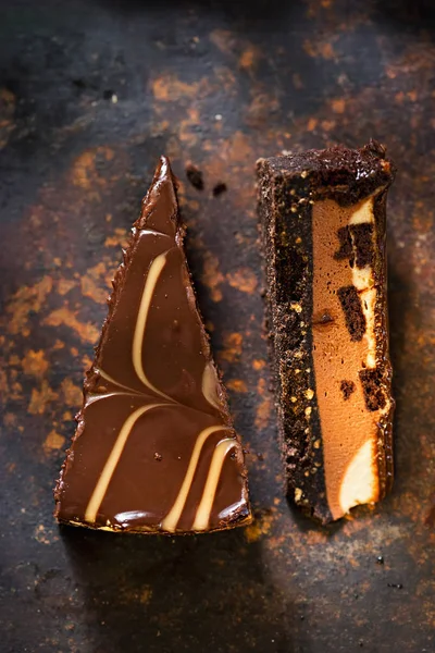 Tranches de gâteau au fromage brownie au chocolat. Gâteau au chocolat et au caramel avec morceaux de brownie sur base de biscuits au chocolat . — Photo