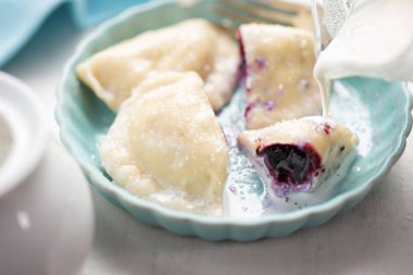 Yaban mersini ve krema ile mantı. Berry meyve tatlı pierogi.