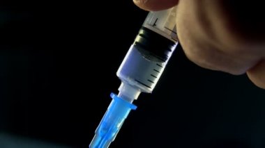 Doktor enjeksiyon yapıyor. Sıvı madde şırınga içinde