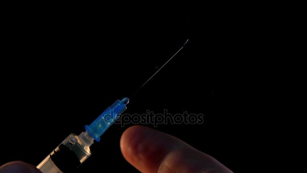 Le docteur clique sur la seringue avec l'injection pour recueillir et libérer des ampoules d'air 