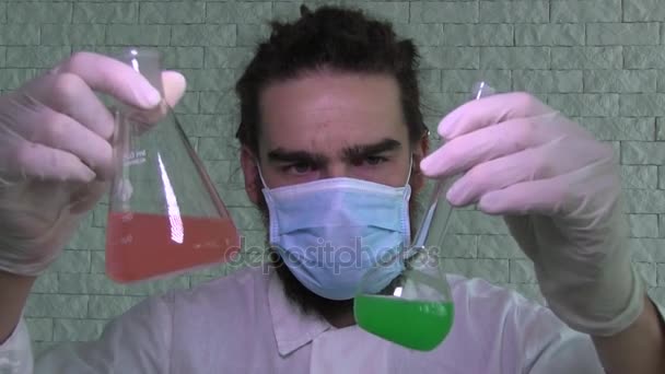 Laboratory Assistant In A Face Mask And Latex Gloves Is Shaking A Flask, Making Laboratory Tests — Stock Video