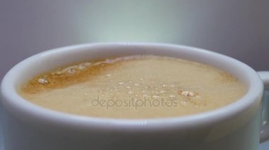 Köpük bir beyaz fincan ya da cam hava kabarcıkları ile kahverengi içecek