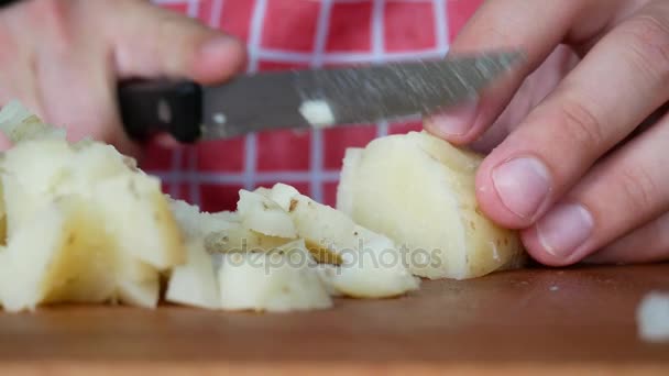 Gekookte aardappelen snijden op hakken bord met mes — Stockvideo