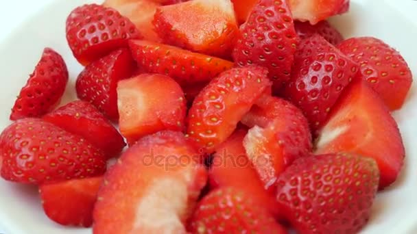 Czerwony dojrzałe soczyste truskawki w plasterkach na białym talerzu — Wideo stockowe