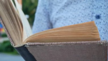 Mavi Beyaz tişörtlü adam eski kahverengi kitap okuma