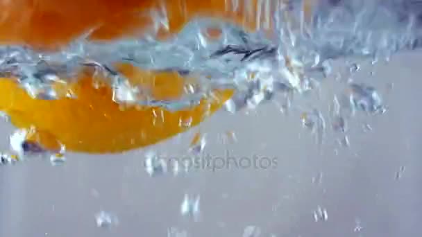 Fruit orange frais plongeant et éclaboussures gouttes sous l'eau 