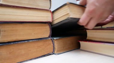 Kitaplık üzerine eski kitaplar alarak