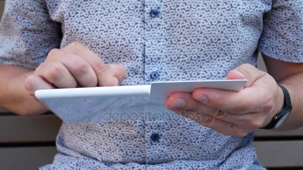 Кредитная дебетовая карта в руке с планшетным ПК — стоковое видео