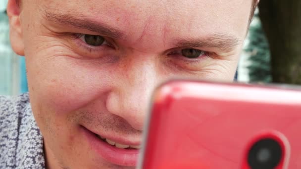 Руки, що друкують смс на червоному смартфоні — стокове відео