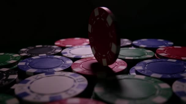 Red Poker Chips gira na mesa na escuridão — Vídeo de Stock