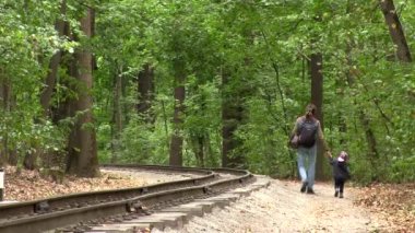 Baba ve kızı orman Demiryolu boyunca sonbaharda yürümek