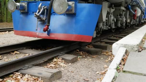 Départ du train bleu sur les rails en forêt à l'automne — Video