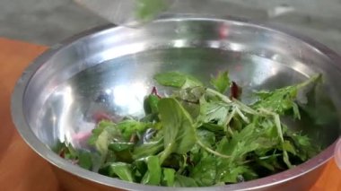 Şefler eller vegan meyve salatası yapmak için yeşil yaprakları yaymak