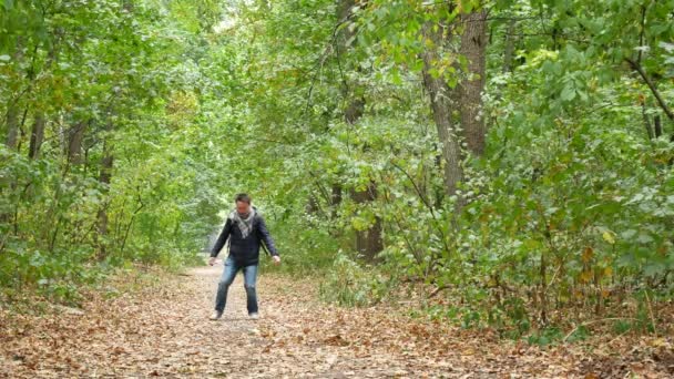 Милый мужчина, гуляющий в лесу осенью — стоковое видео