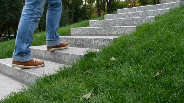 Man in spijkerbroek stijgt over graniet stappen op geheugen muur of Tombstone — Stockvideo