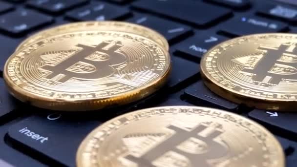 Gold-Bitcoin-Coins rotieren auf Laptop-Tastatur — Stockvideo