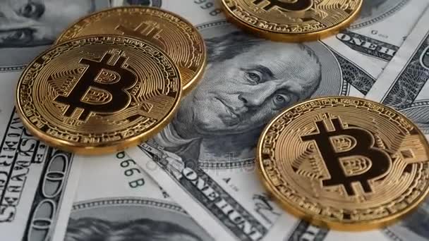 Moedas de ouro Bitcoin BTC girando em notas de 100 dólares — Vídeo de Stock