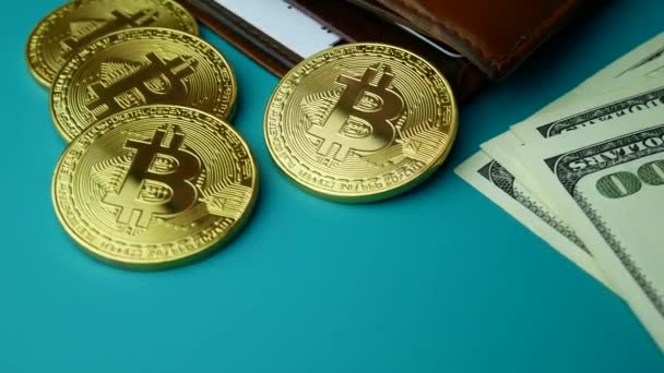 Złote monety Bitcoin Btc obrotowa z brązowy portfel i rachunki za 100 dolarów — Wideo stockowe