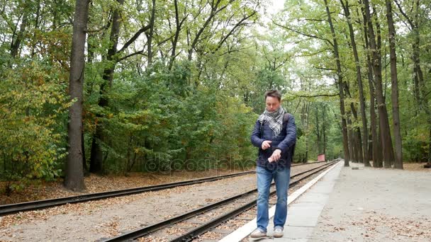 年轻男子检查火车晚点时间的旅行者 — 图库视频影像