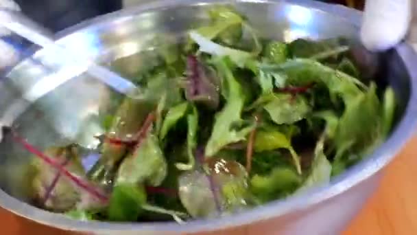 Руки шеф-повара распространили зеленые листья, чтобы сделать веганский фруктовый салат — стоковое видео