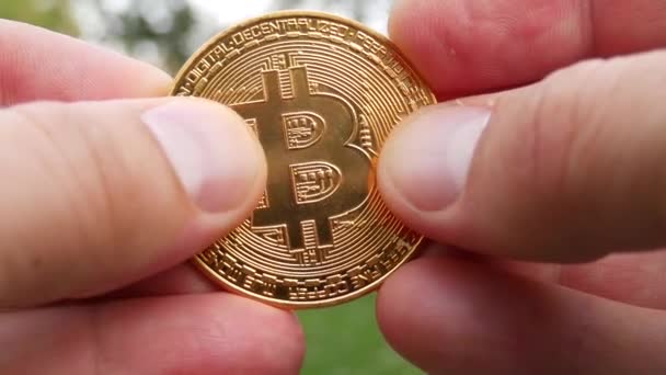 Криптовалюта BTC Bitcoin в руках — стоковое видео