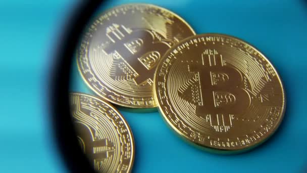 Guld Bitcoin Btc mynt och förstoringsglas eller lupp — Stockvideo