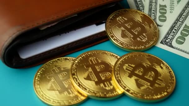 Złote monety Bitcoin Btc obrotowa z brązowy portfel i rachunki za 100 dolarów — Wideo stockowe