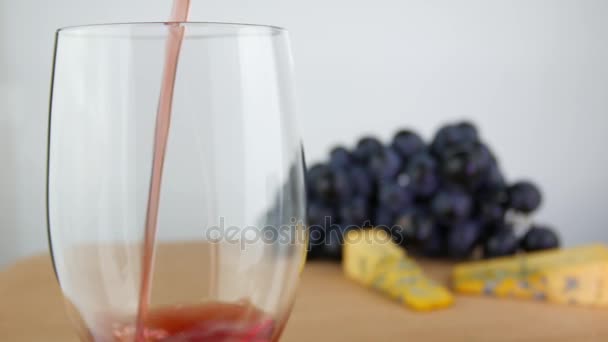 Vin rouge coulé dans le verre sur la surface en bois — Video