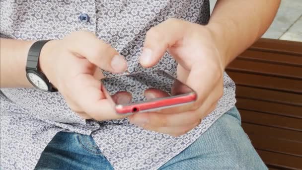 Handen typen sms op rode smartphone — Stockvideo