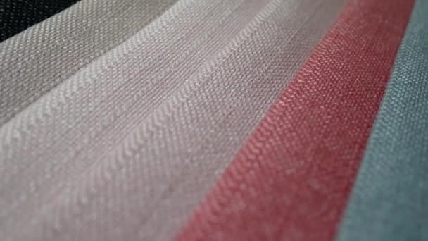 Des échantillons de tissu de différentes couleurs en mouvement tournent et tournent — Video