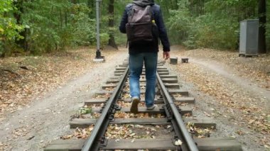 İnsan platform tren rayları arasında yürüyor.