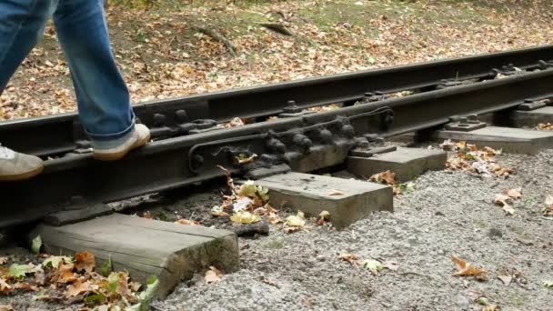 El hombre camina entre los rieles del ferrocarril — Vídeos de Stock