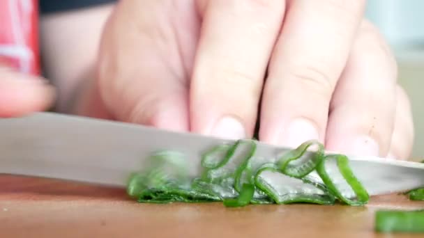 Groenen verse ui snijden op hakken bord met mes — Stockvideo