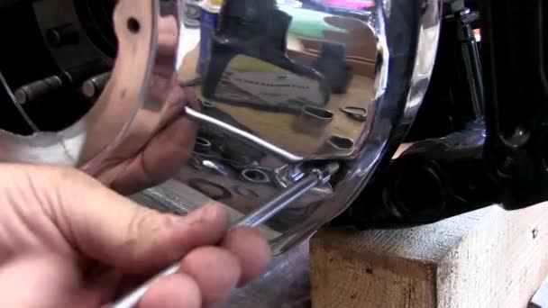 Мотомеханик собирает мотоцикл в мастерской — стоковое видео
