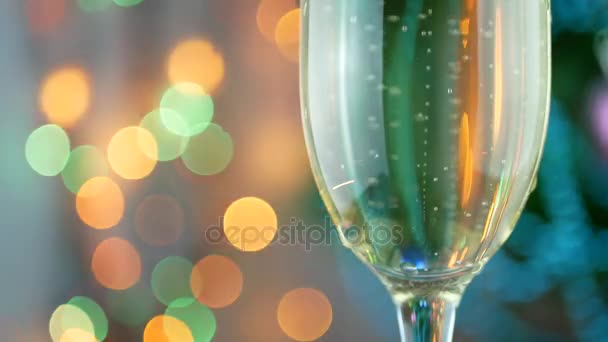 Champagne pourinto glas met kerstverlichting — Stockvideo