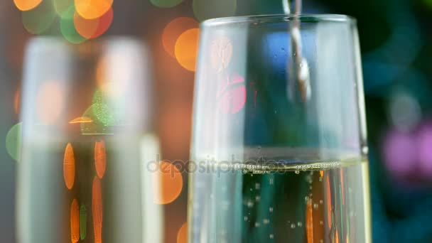 Искрящееся вино на фоне мигающего праздника боке — стоковое видео