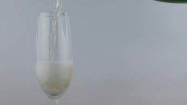 Ayrı tutma beyaz arka plan üzerinde cam içine şampanya pour