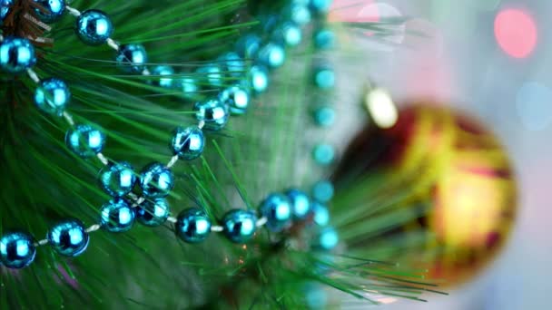 Turquoise decoratieve garland op kerstboom met vervagen kerstballen — Stockvideo