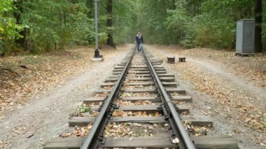 Tren rayları arasında insan yürüyor
