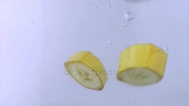 Падение банановых фруктов и брызги воды — стоковое видео
