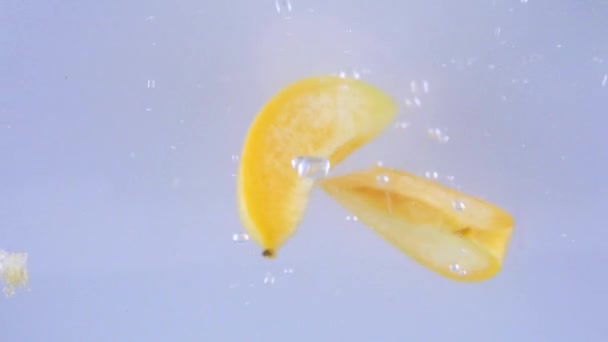 Des morceaux d'abricots tombent sous l'eau 