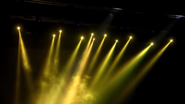 Желтые прожекторы в дыму в темноте — стоковое видео