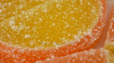 Şekerlenmiş meyve jöle beyaz bir arka plan üzerinde dönen sarı ve kırmızı tatlı şeker