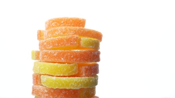 黄色と赤のお菓子砂糖白い背景の回転砂糖漬けの果物ゼリー — ストック動画